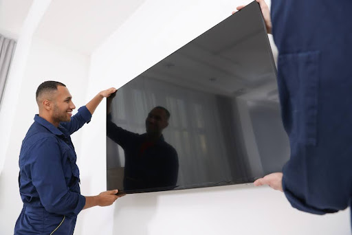 Movers mounting a TV.