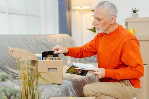 Elderly man sorting through stuff.