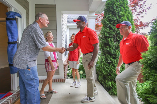 Wheaton employee shaking hands with elderly couple.