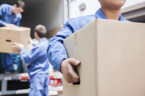 men loading boxes out of a moving truck