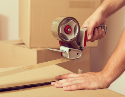 Taping up a cardboard box. What are the best ways to make packing for a move less stressful?