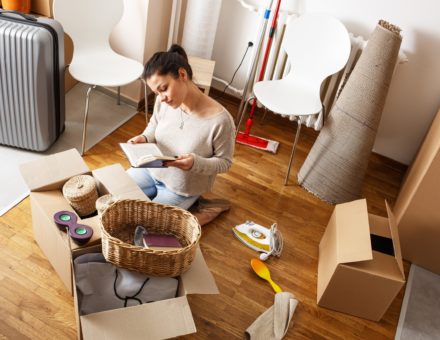 Young woman unpacking items from cardboard box