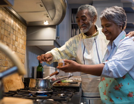 Smiling senior couple cook in the kitchen