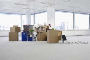 open moving boxes piled up in the center of a white room