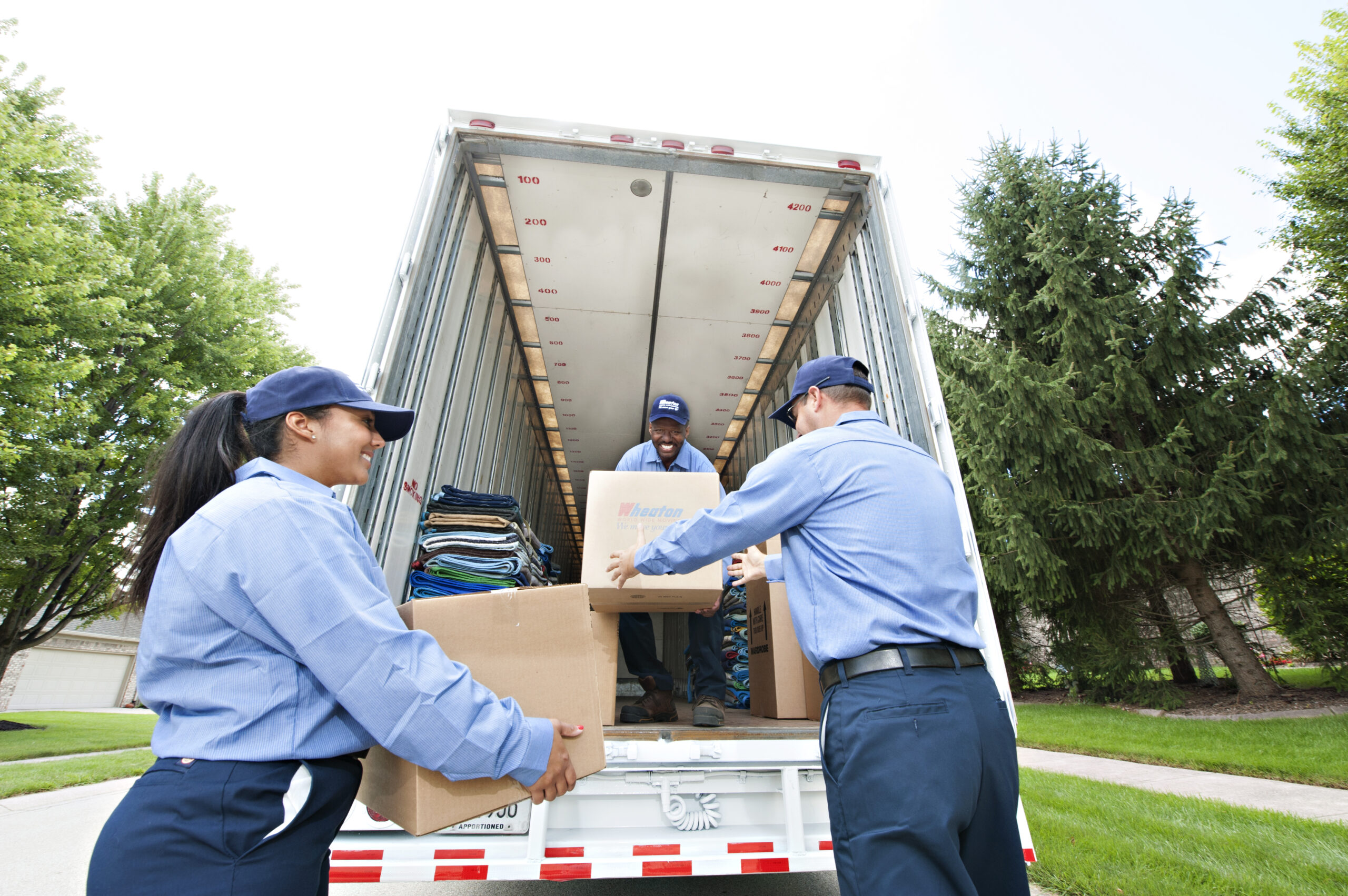 Professional movers putting boxes into moving truck. 