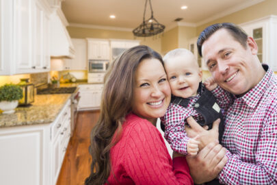 family of three smiling in kitchen