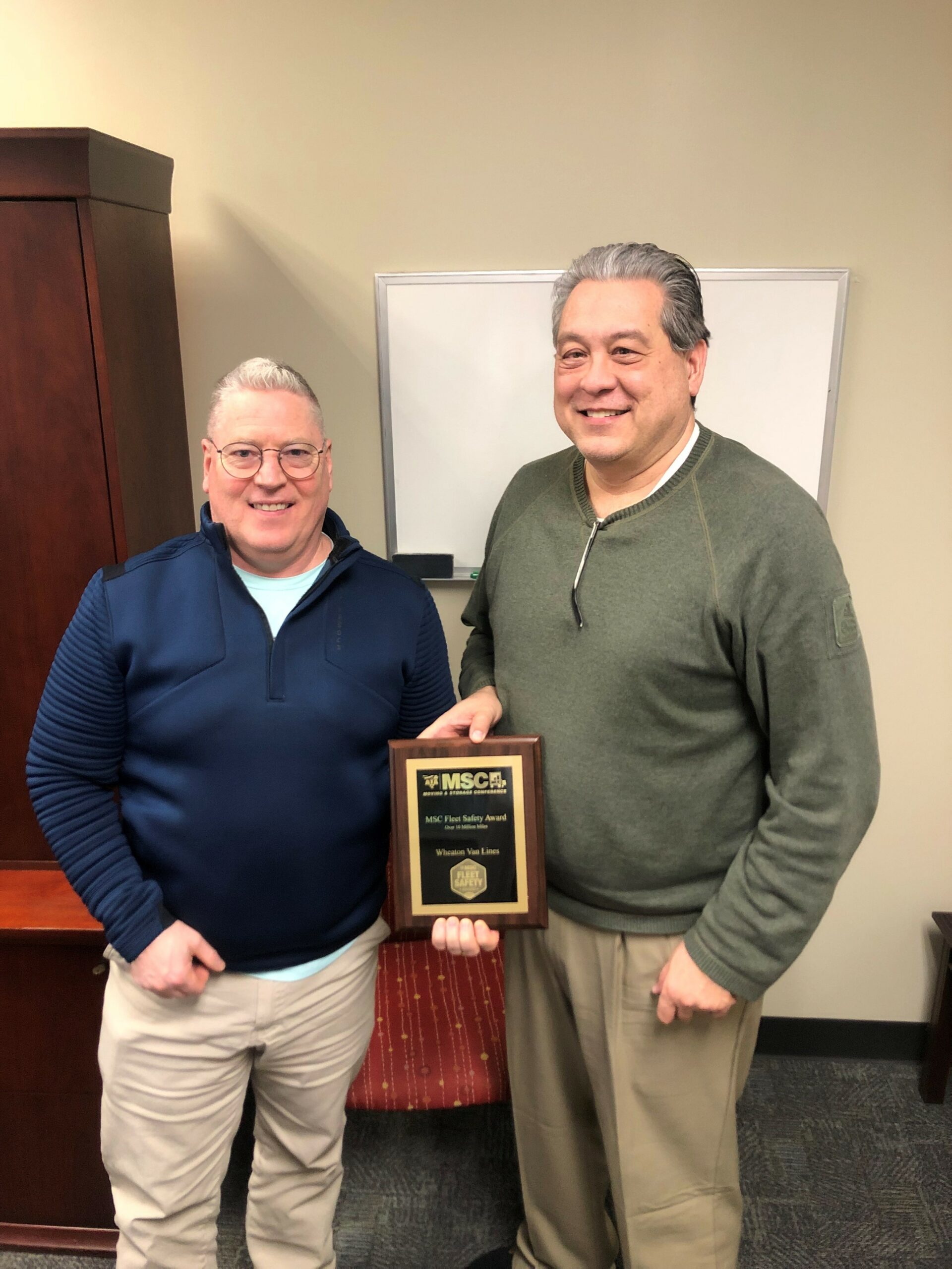 Kevin Miller (left) and Jim Witzerman of Wheaton World Wide pose with 2023 Fleet Safety award from American Trucking Association.