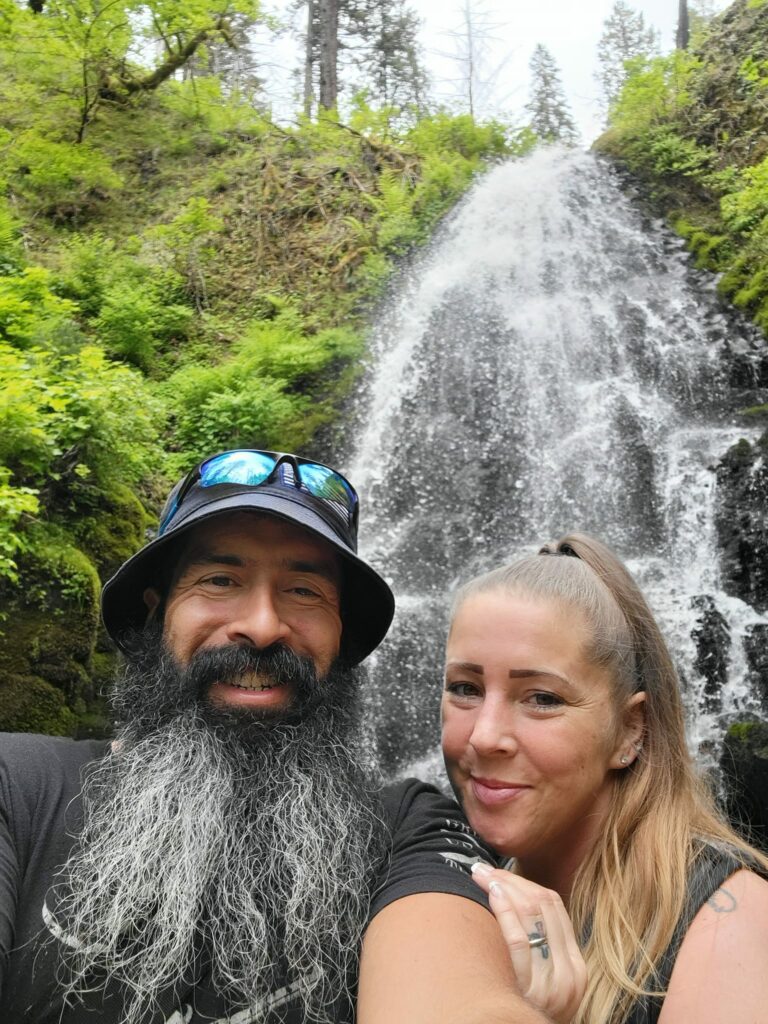 Marc Bailey, 2022 Wheaton Driver of the Year, with his wife Mandy in front of a waterfall