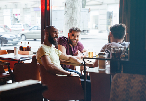 Friends gathered around a table in a restaurant and smiling.