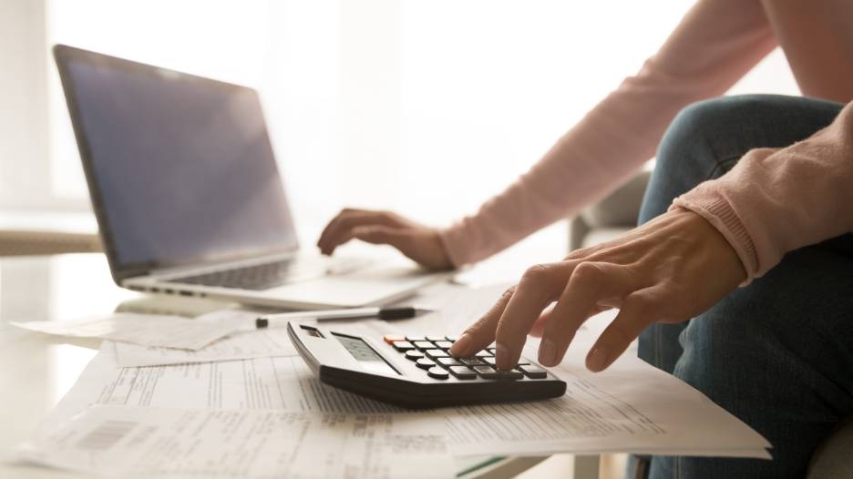 Woman on computer and calculator 