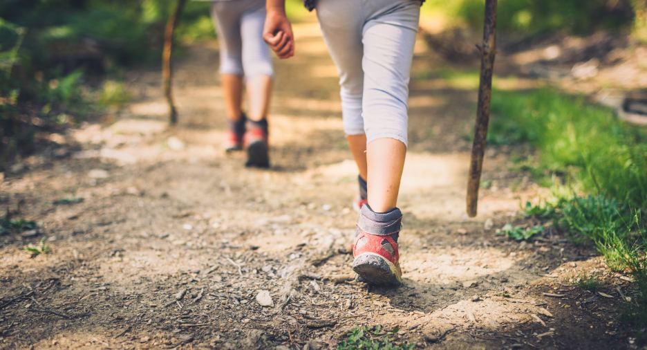 Two people walking on dirt trail