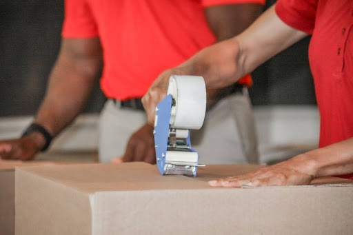 Wheaton employee taping a box.