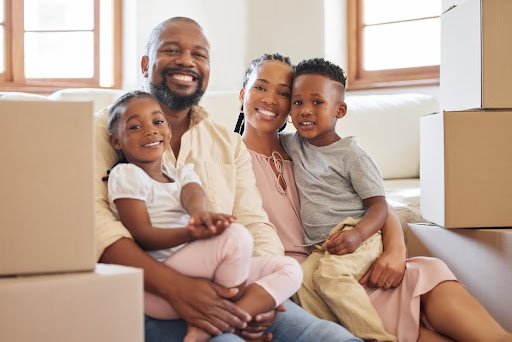 Family surrounded by boxes, smiling.