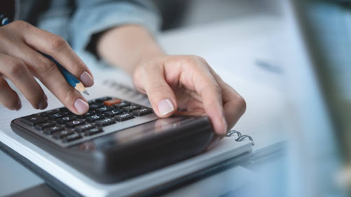 Close up of a hand using calculator.